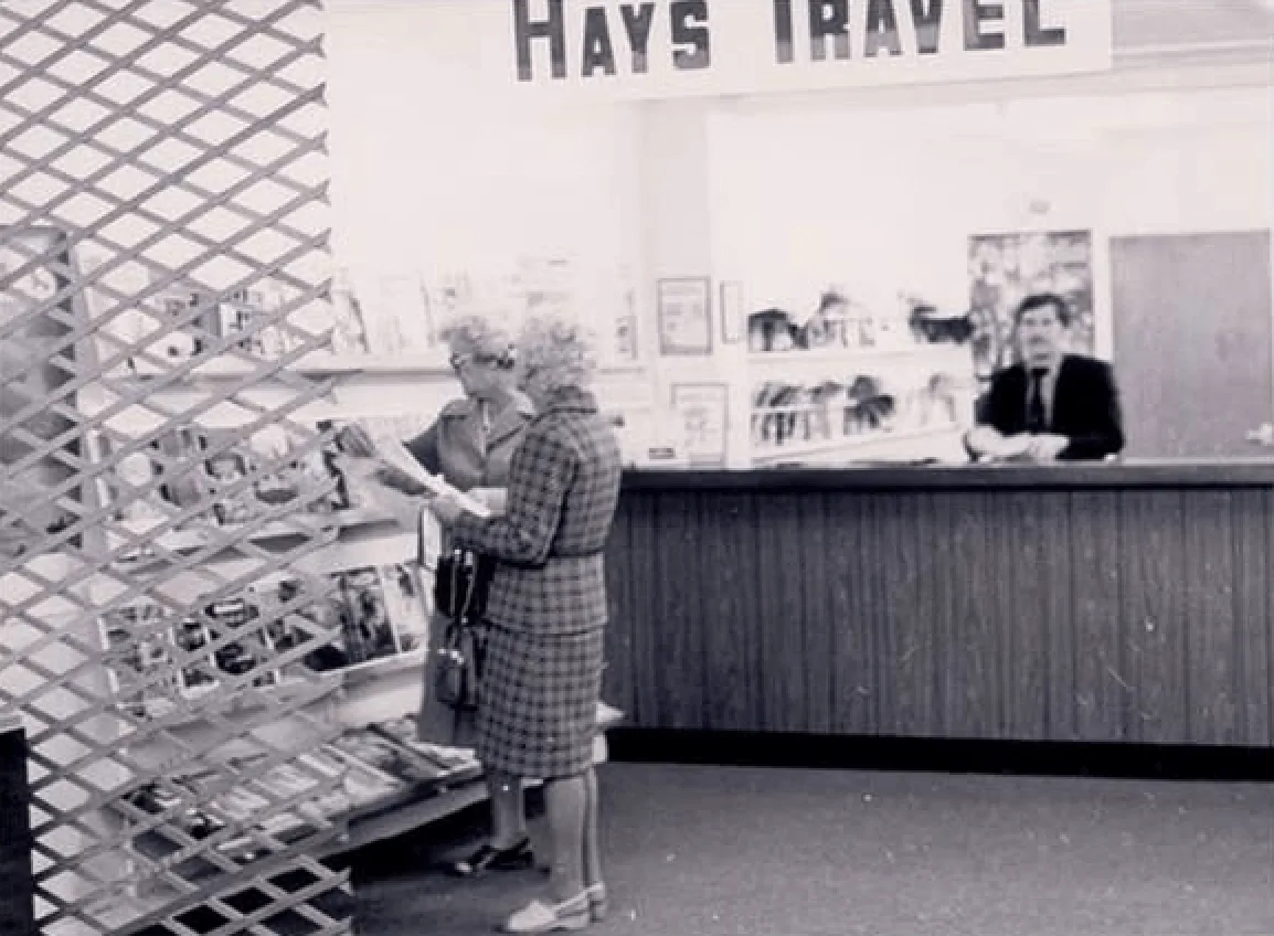 Hays Travel’s first premises in Seaham in 1980, operating from the back of John Hays’s mother’s babywear shop. A trellis separated the travel business from the clothing store. Source: Facebook
